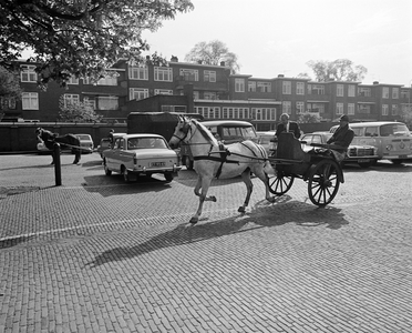 850382 Afbeelding van een dravend paard voor een boerendresseerkar, op het voorterrein van de Veemarkthal (Croeselaan) ...